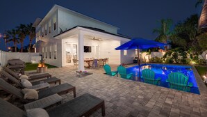 Een huis met een zwembad, terras en een overdekte patio.