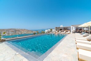 Une piscine avec vue sur la mer et une ville en arrière-plan.