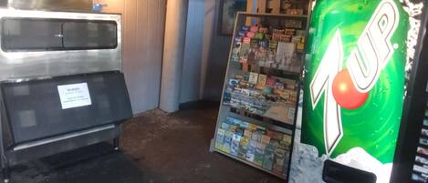 A vending machine with a 7UP logo, a freezer, and a display of mobile brochures.