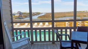 A balcony with a view of a river, wooden deck, and outdoor seating. - Seawatch Inn at the Landing (Murrells Inlet)