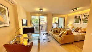A modern living room with a glass dining table, a red chair, a sofa, and a bed. - Home2Book El Encanto 3 de Mayo (Santa Cruz de Tenerife)