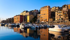 A marina with boats docked, surrounded by multi-story buildings with balconies and windows. - Residence Pasturella, Large studio 30m2, swimming pool, countryside (BASTIA)