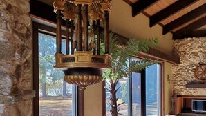 Ein gemütliches Wohnzimmer mit Steinwand, großem Fenster, Holzboden und Kamin.