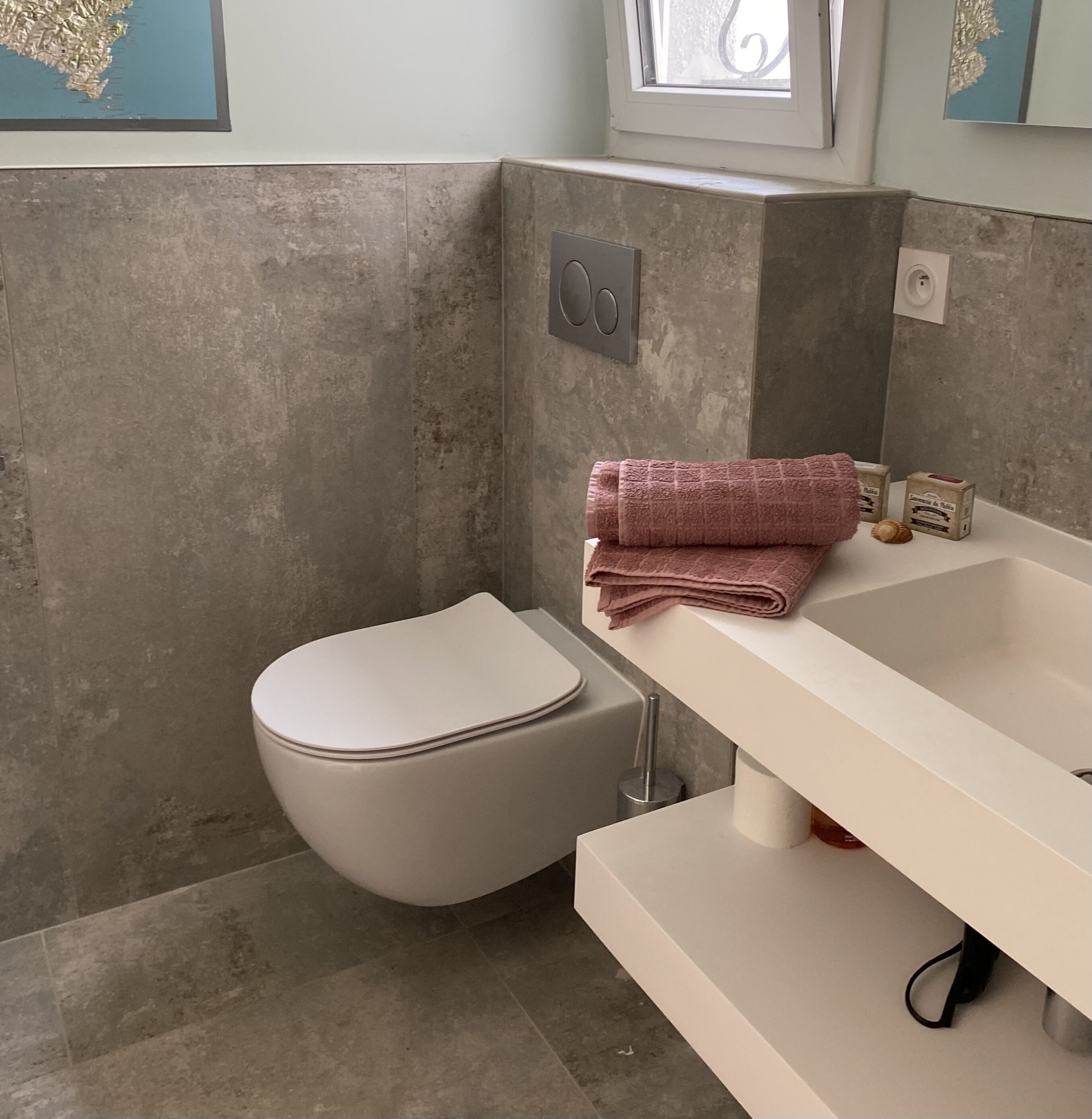 A bathroom with a toilet, sink, and towel.