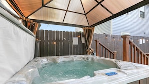 A hot tub with a wooden deck and a covered area. - Lux Brand New! Beautiful House w/ Pool & Hot Tub (New Orleans)