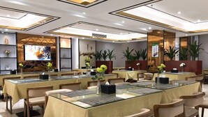 A conference room with glass tables, beige chairs, and potted plants. - Rodin Oswey Hotel (Luoding)