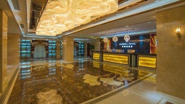 A spacious lobby with a reflective marble floor, a large illuminated chandelier, and a reception desk displaying the hotel name. - Rodin Oswey Hotel (Luoding)
