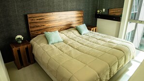 A bed with a wooden headboard, two pillows, and a vase with flowers on a wooden nightstand. - Tiny Apartment with Rooftop pool y GYM (Mexico City)
