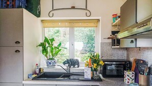 A kitchen with a window, a sink, a stove, and cabinets.