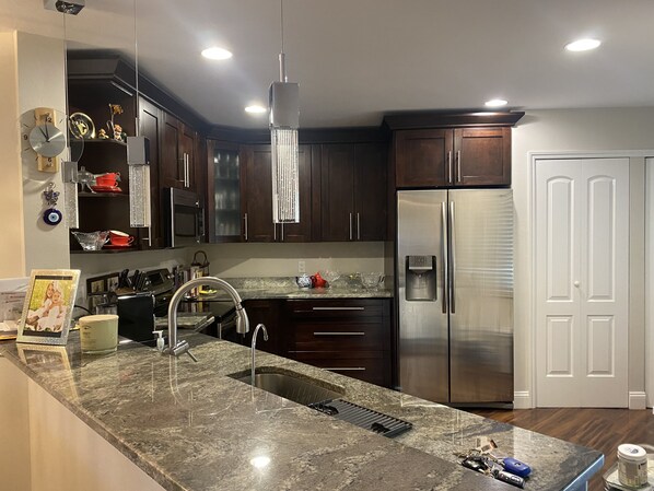 Enjoy cooking in this well-equipped kitchen with a sink, granite countertop, and stainless steel appliances.