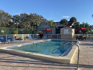 Relax by the pool surrounded by lush greenery and comfortable lounge chairs.