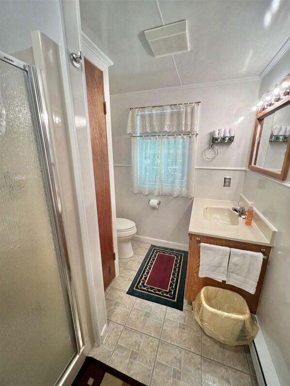 Ein kleines Badezimmer mit Toilette, Waschbecken und Duschbereich.