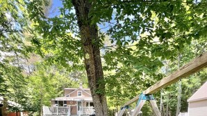 A wooden swing set in a grassy yard with a house in the background. - Great Place for a Family Retreat! Sleeps 10 (Naples)
