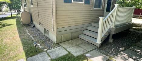 A single-story house with a front porch and a small deck.