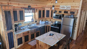A cabin-style kitchen with wooden cabinets, a stainless steel refrigerator, a microwave, and a coffee station. - Mountain View Cabin,15 Min to Casino, Family Friendly (murphy)