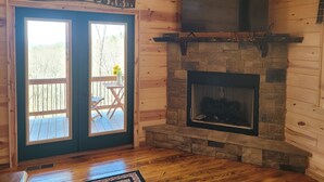 A cabin interior with a stone fireplace, a wooden ceiling, and a sign reading "WELCOME HOME CABIN". - Mountain View Cabin,15 Min to Casino, Family Friendly (murphy)