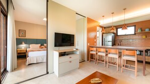 A modern kitchen with a dining area, a TV, and a bed in the adjacent room. - Reservas dos Lagos - Boa Luz (Laranjeiras)