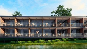 A modern building with multiple balconies, large windows, and a water body in front. - Reservas dos Lagos - Boa Luz (Laranjeiras)