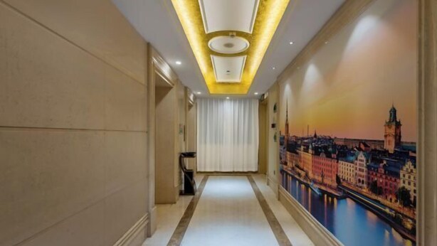 A hallway with a cityscape mural, a white curtain, and a modern ceiling design.