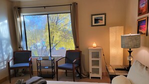 Ein Hotelzimmer mit einem Bett, zwei Stühlen, einem kleinen Tisch, einem Schrank und einer Lampe.