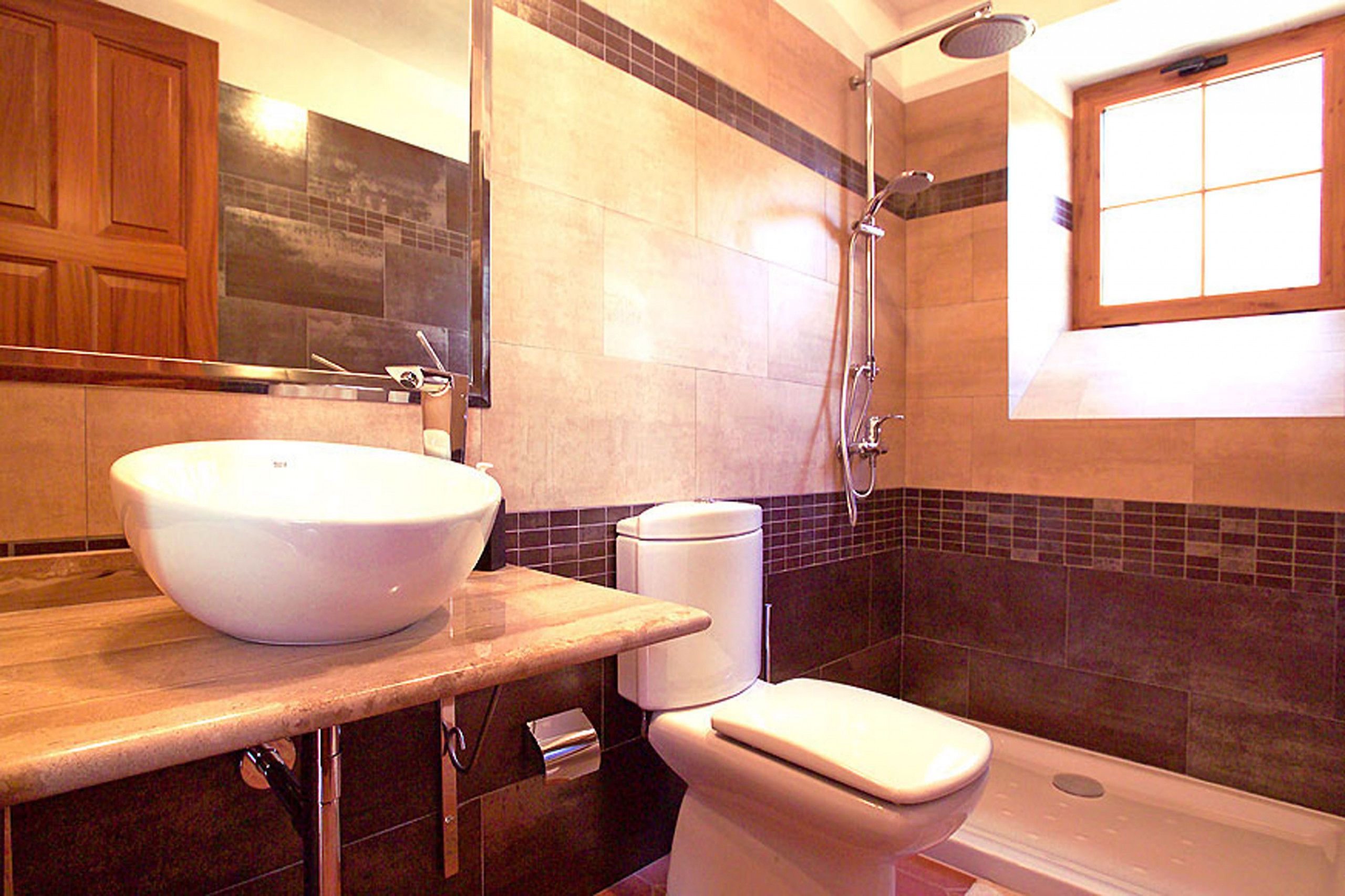 Un baño con un lavamanos grande blanco, un inodoro y una ducha.