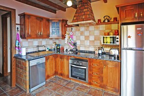 A kitchen with wooden cabinets, a dishwasher, an oven, a microwave, and a refrigerator.
