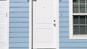 Un bâtiment bleu avec une porte blanche portant le numéro 4.