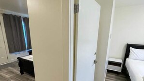 Une chambre d’hôtel avec un lit, une table de chevet et un miroir.