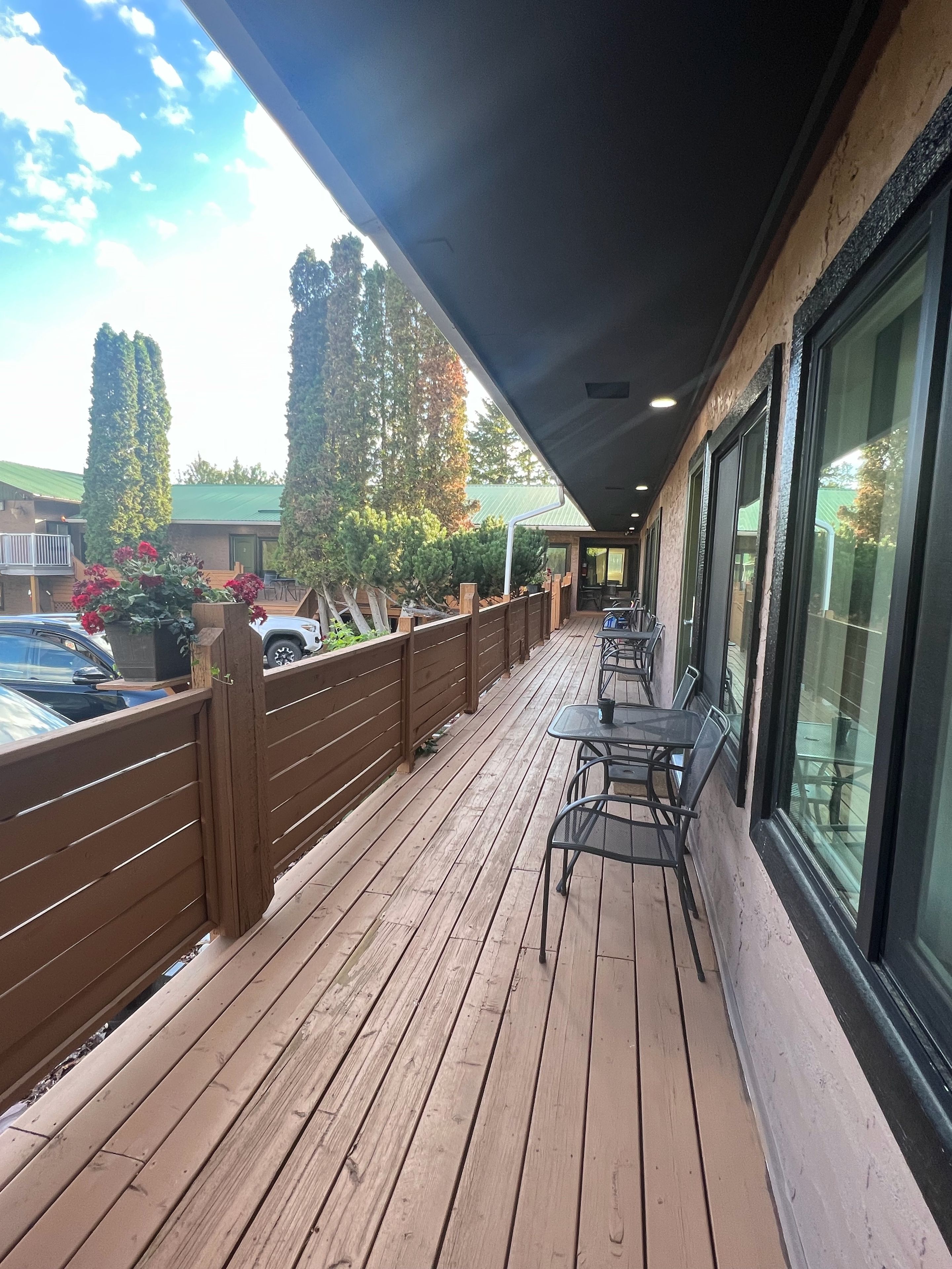 Une terrasse en bois avec des sièges extérieurs et une vue sur le ciel.