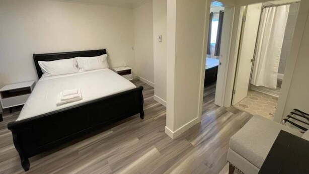 Une chambre à coucher moderne avec un lit, des tables de chevet et un dressing.