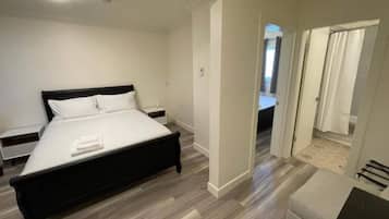 A modern bedroom with a bed, bedside tables, and a walk-in closet.