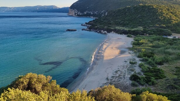 A coastal landscape with a beach, clear blue waters, and a mountain. - Villa Capelvenere (Corbezzolo) (Dorgali)