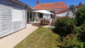 A house with a patio, a dining area with outdoor furniture, and a satellite dish. - Villa pornic 8/9 persons sea view 1min from the beach (Pornic)