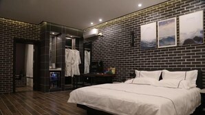 A modern hotel room with a brick wall, a large bed, a wardrobe, and a mirror. - Shou Cheng Hotel Select (Mishan)