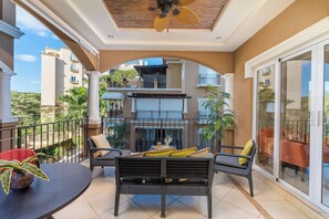 A balcony with outdoor furniture, a ceiling fan, and a view of neighboring buildings.