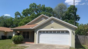 A single-story house with a garage, a front porch, and a small front yard.