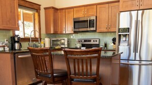 A kitchen with wooden cabinets, stainless steel appliances, a built-in oven, and a refrigerator. - Fully Stocked Family Friendly Cabin Near Breckenridge (Fairplay)