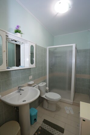 Un baño con lavamanos, inodoro y ducha.