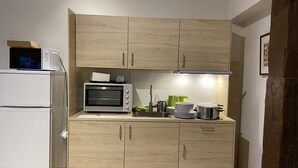 Une cuisine compacte équipée d’un four à micro-ondes encastré, d’un grille-pain et d’un évier.