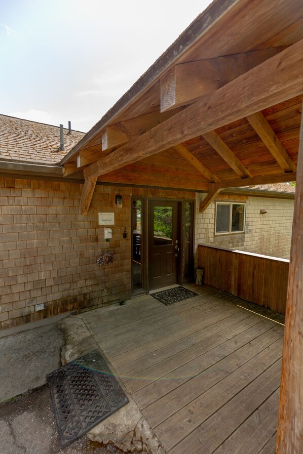 A wooden building with a brick exterior, a covered porch, and a door labeled "Headland."