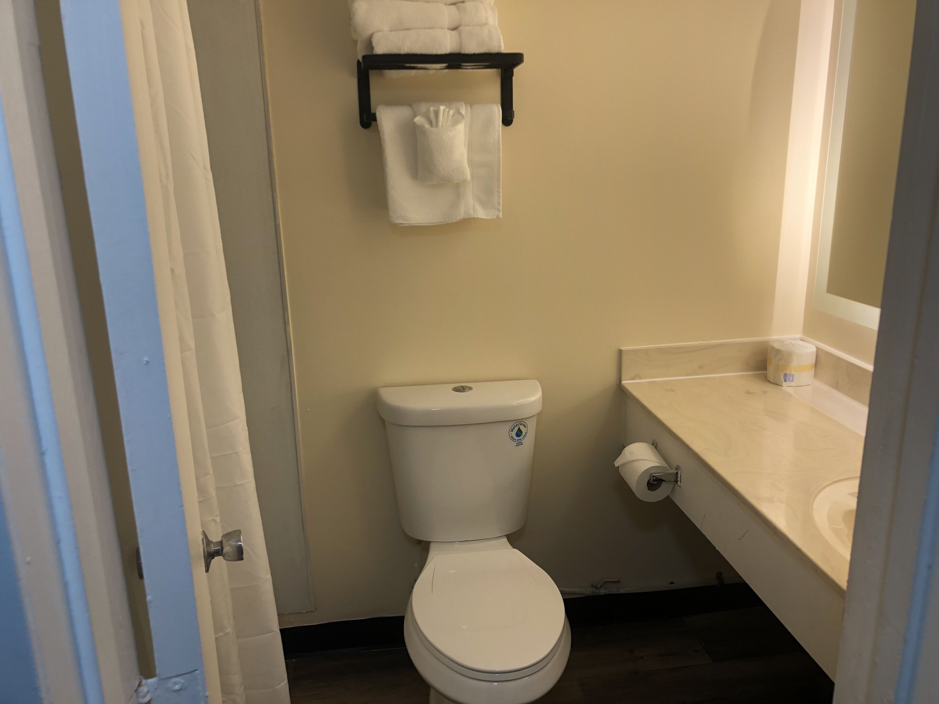 A small bathroom with a toilet, a towel rack, and a sink.