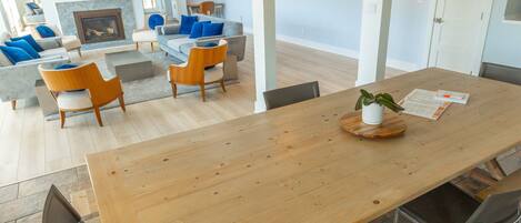 Un vaste espace de vie comprenant une table à manger en bois, des bancs et une cheminée.