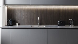 Eine moderne Küche mit Holzrückwand, Spüle aus Edelstahl und einem Toaster.