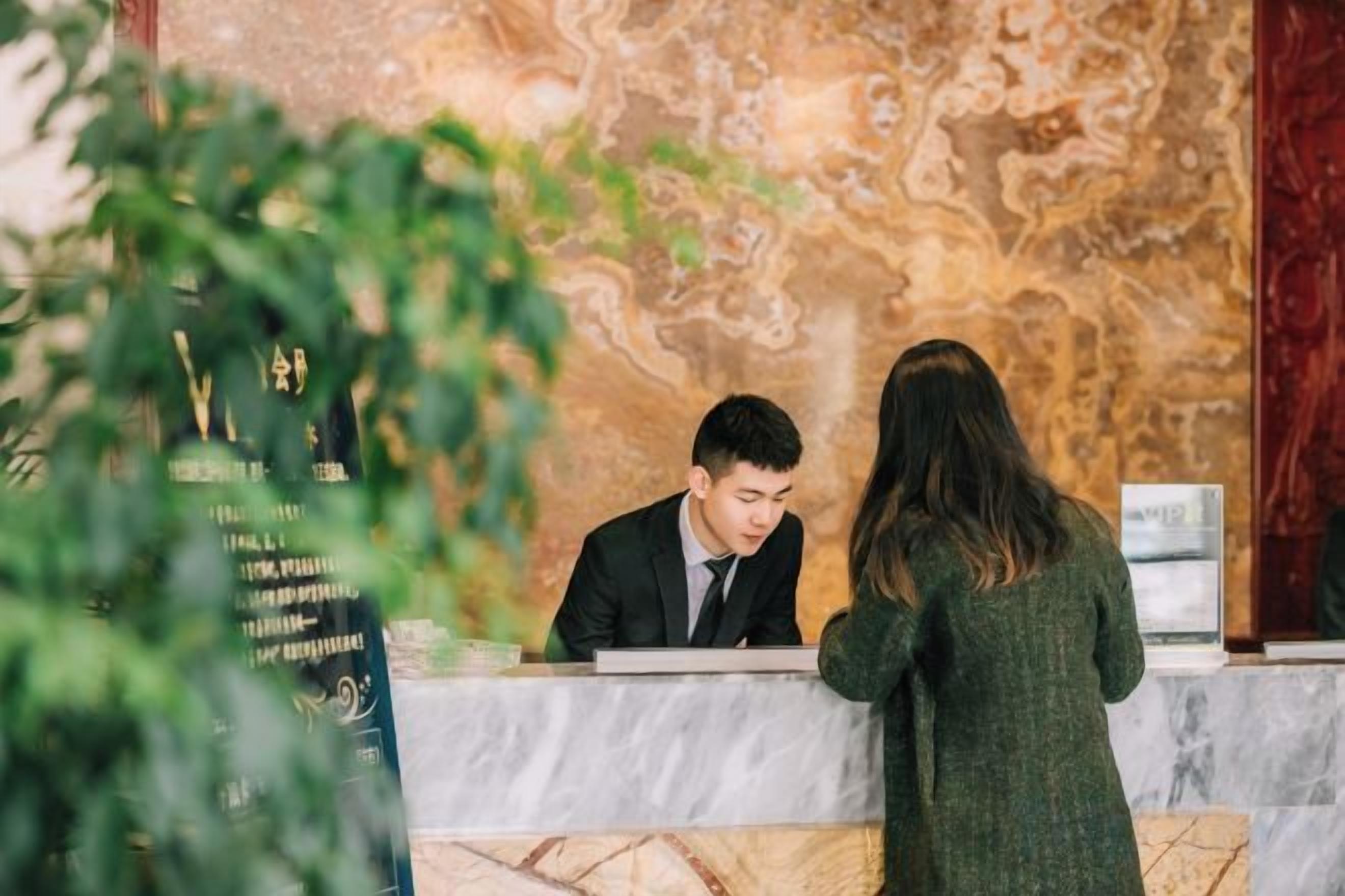 A reception desk with a marble counter and a wall with a marbled pattern.