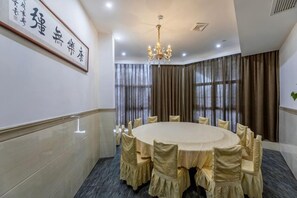 A conference room with a round table, chairs, and a chandelier. - Zhongpu Hotel (Shangrao)