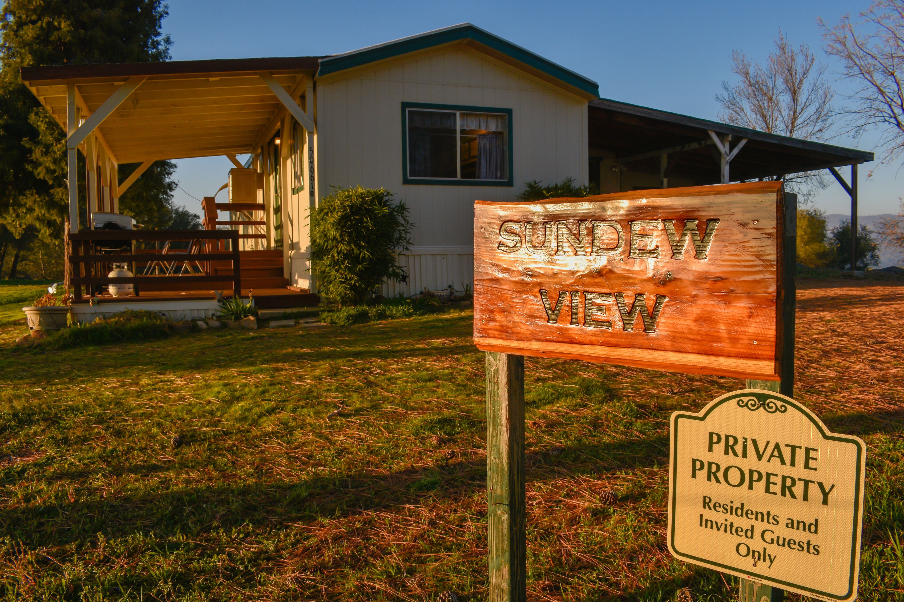 A wooden sign reading "SUNDEW VIEW" and a "PRIVATE PROPERTY" sign indicating residents and invited guests only.