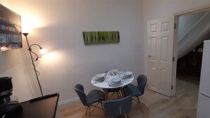 A dining area with a table set for six, a refrigerator, and a staircase leading to another level. - Privet apartment with 2 bedrooms for relaxing escape in EastHam near CentralPark (London)