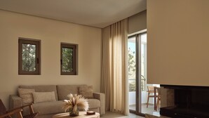 Un salon moderne avec un canapé, une table basse, un téléviseur et une cheminée.