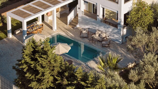 Une maison moderne à deux étages dotée d’une piscine, d’un espace extérieur aménagé et d’un patio couvert.