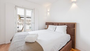 Ein Schlafzimmer mit einem großen Bett, einem Balkon mit Aussicht und einer Tür, die nach draußen führt.